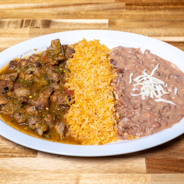 Pork chile verde, orange rice, and refried beans with shredded cheese on a white plate.